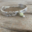 Close up view of upcycled silverware jewelry spoon link bracelet with Peridot stone bead
