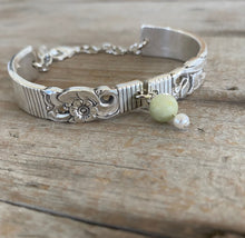 Close up view of upcycled silverware jewelry spoon link bracelet with Peridot stone bead