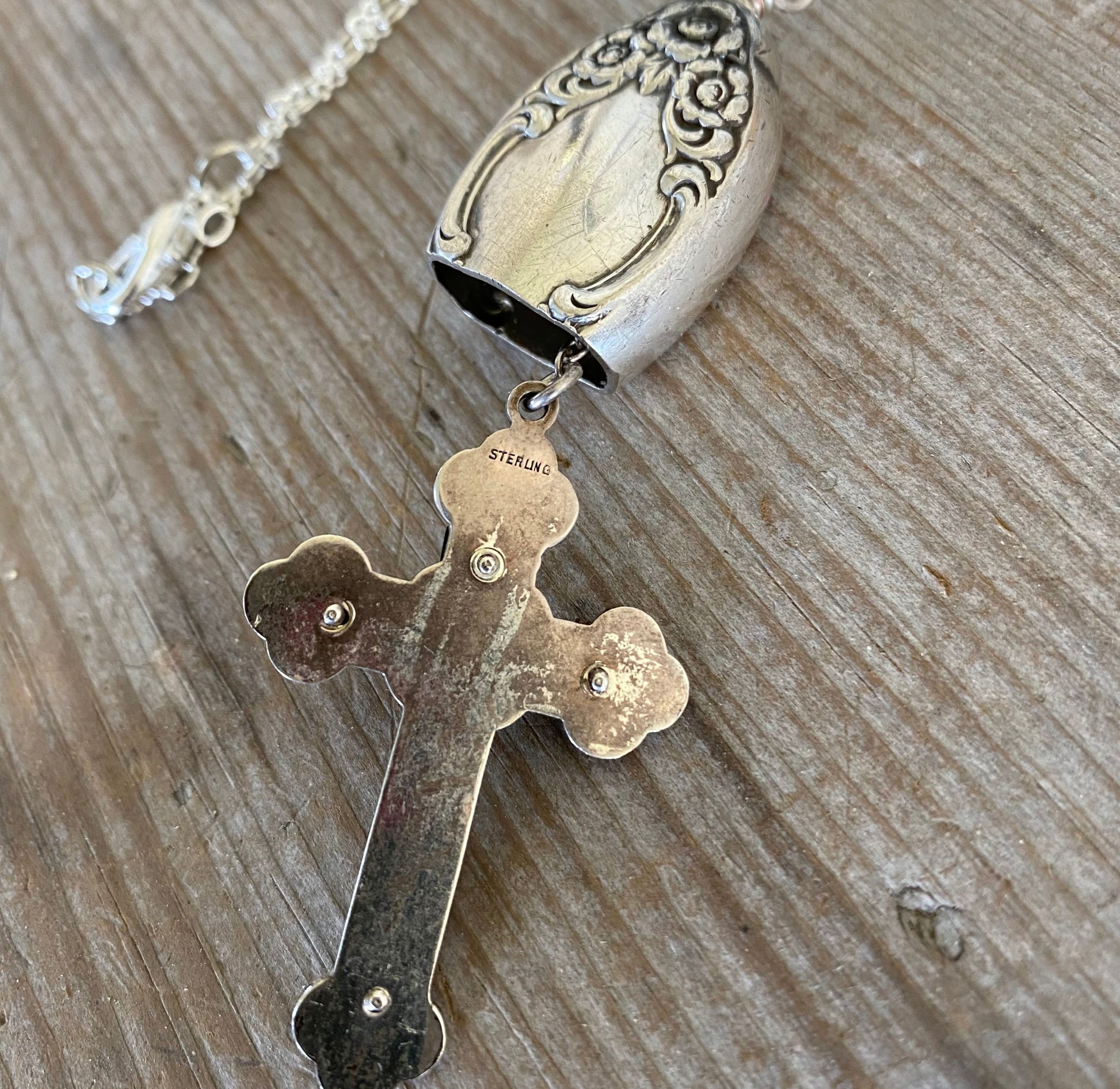 Back of vintage sterling silver rosary cross hanging as clapper indicationg authentic sterling