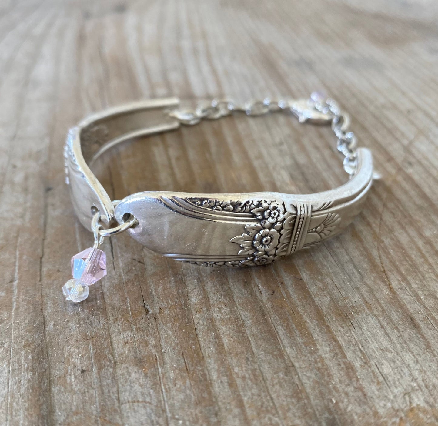 Close-up of handmade FIRST LOVE spoon links showing detailed vintage silverware pattern