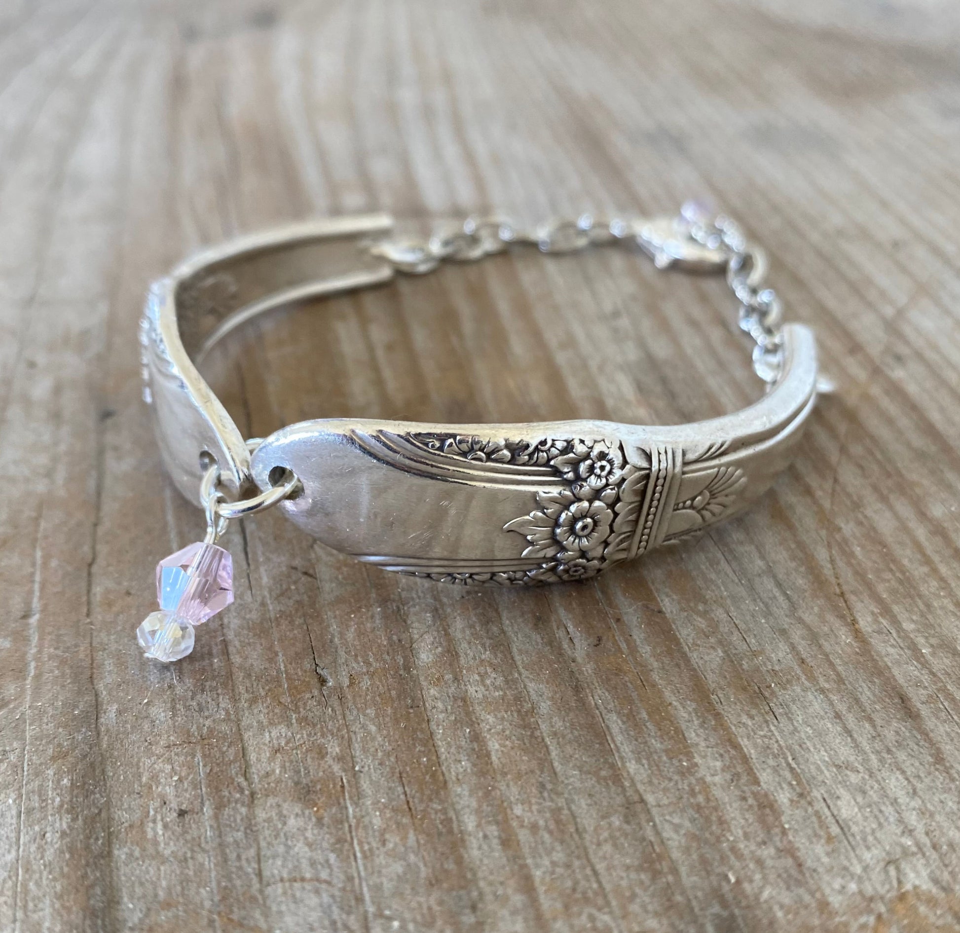 Close-up of handmade FIRST LOVE spoon links showing detailed vintage silverware pattern