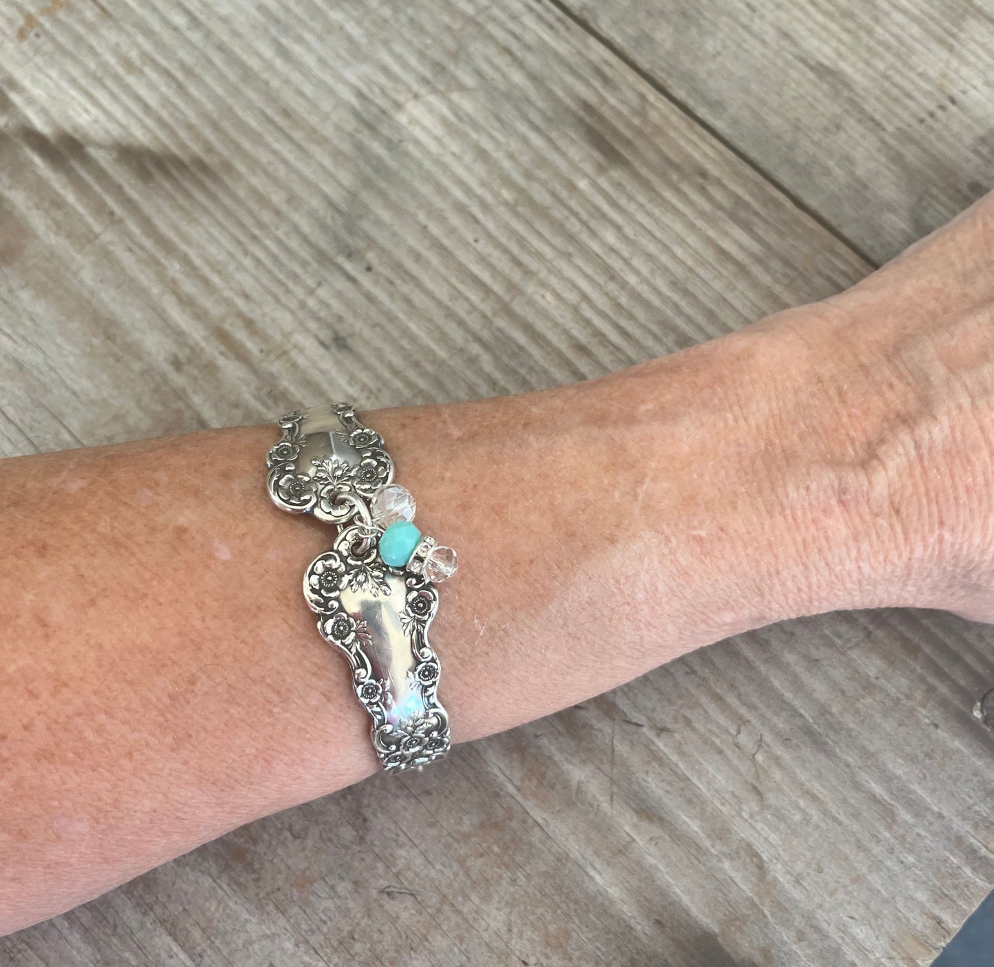 Sterling silver spoon link bracelet worn on wrist showing size and fit