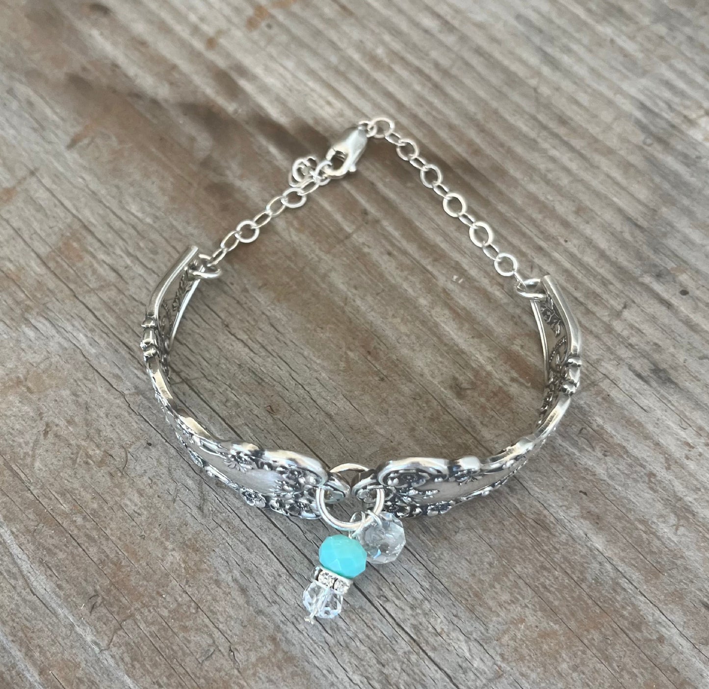 Top view of sterling silver spoon link bracelet displaying vintage silverware construction and clasp mechanism