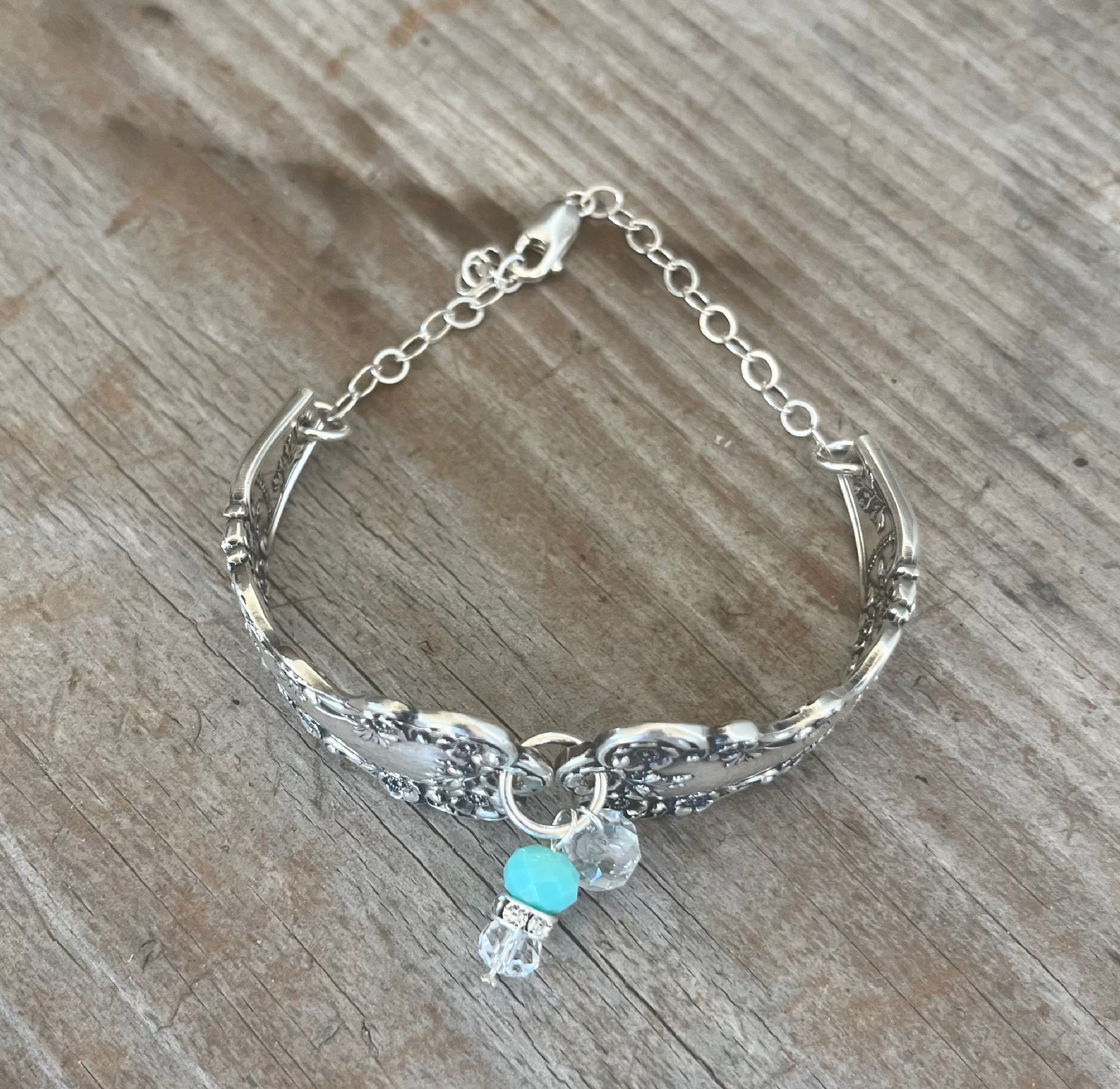 Top view of sterling silver spoon link bracelet displaying vintage silverware construction and clasp mechanism