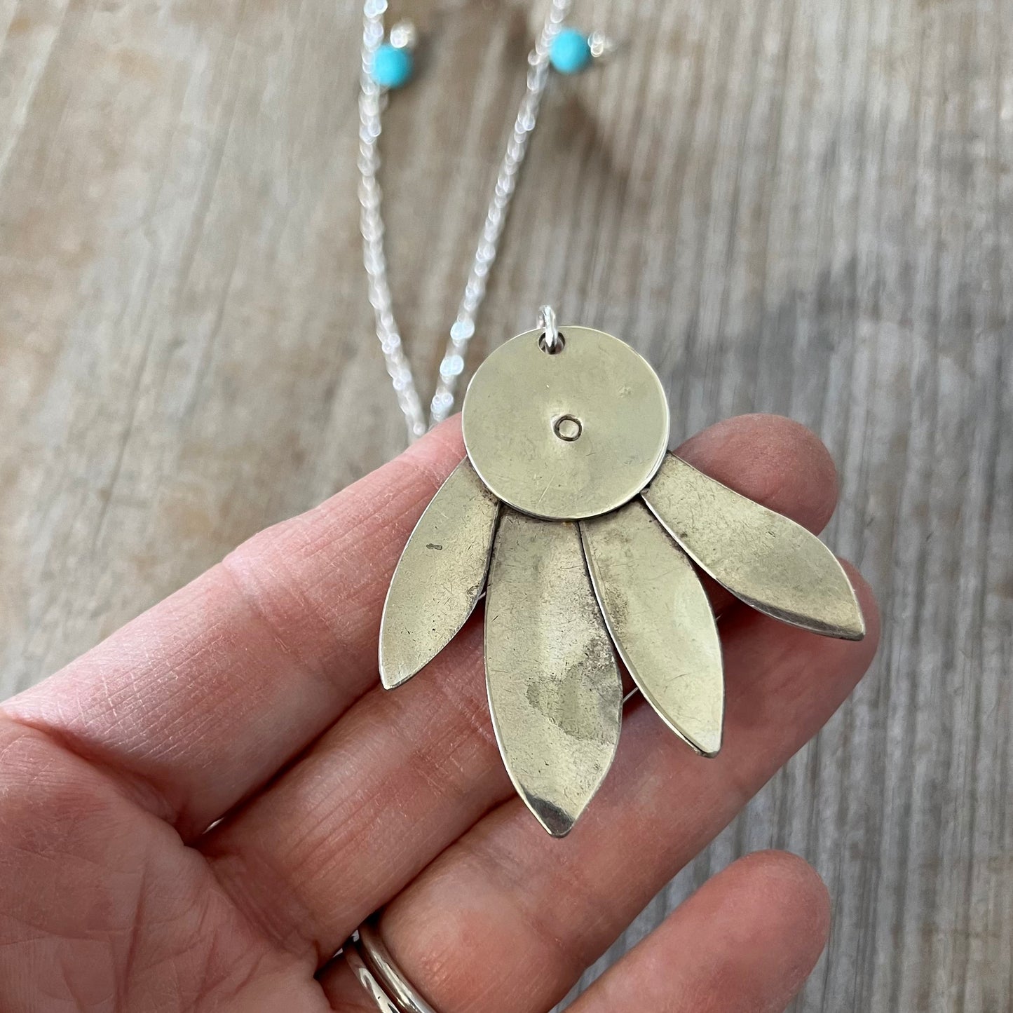 Reverse side of handcrafted vintage spoon pendant necklace with feathery design and stone accents - artisan silverware jewelry