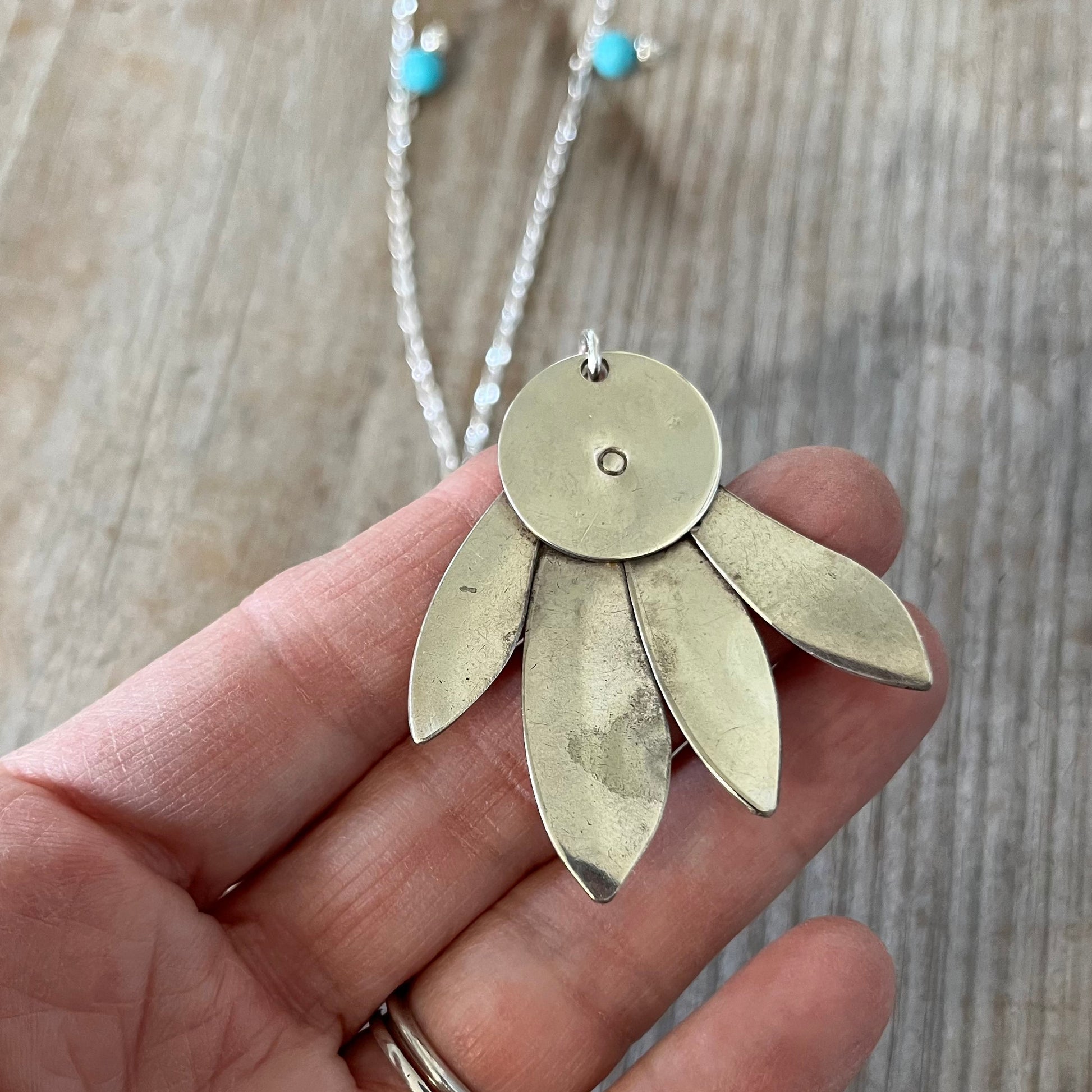 Reverse side of handcrafted vintage spoon pendant necklace with feathery design and stone accents - artisan silverware jewelry
