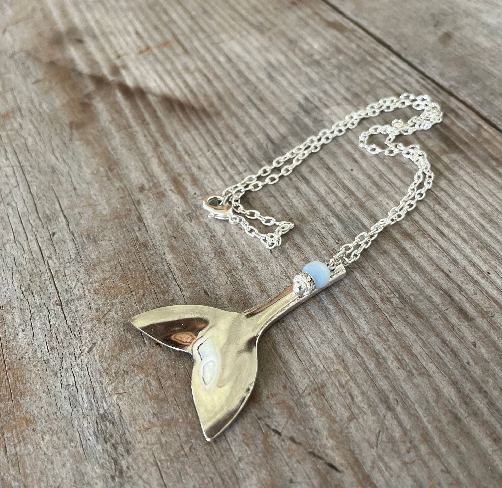 Upcycled vintage silverware mermaid tail necklace styled to show pendant drape, sustainable handmade ocean-inspired jewelry