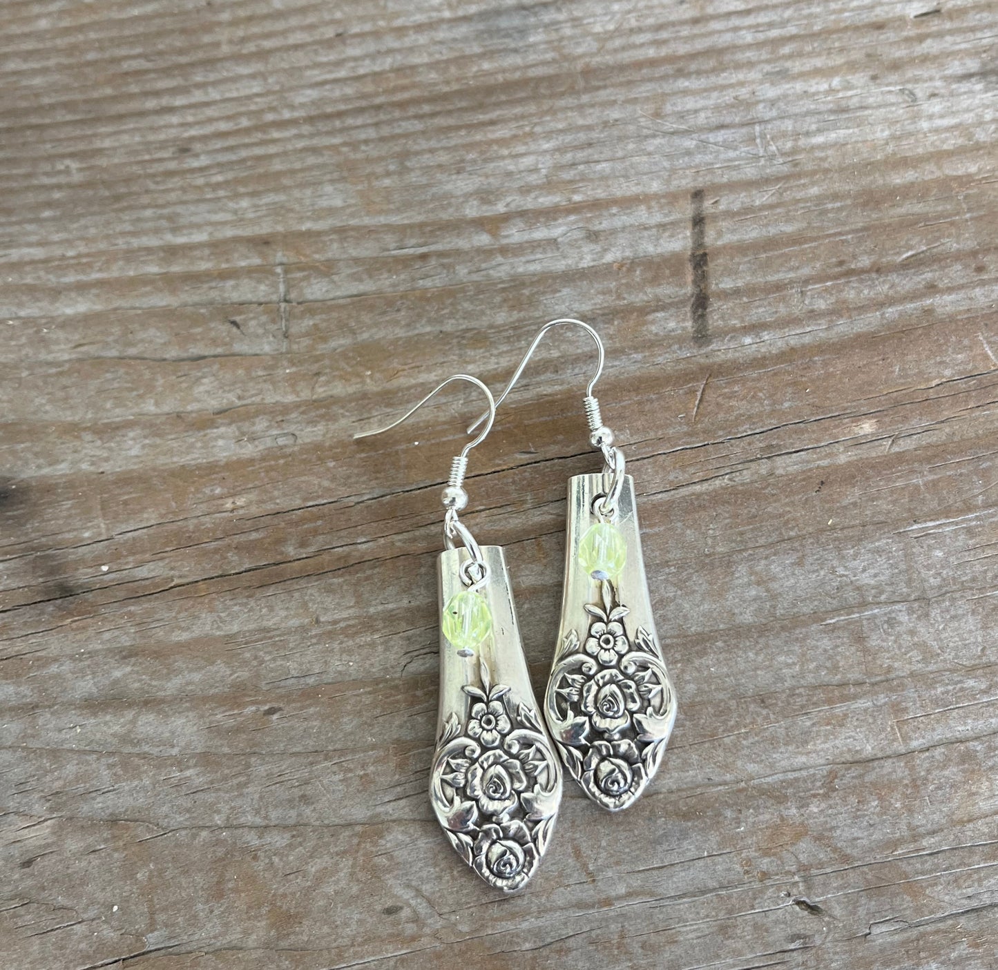 Upcycled spoon earrings showing one-of-a-kind handcrafted design with chartreuse glass accents
