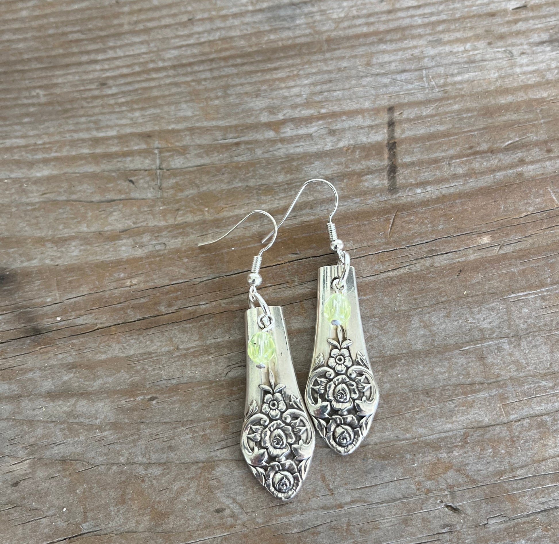 Upcycled spoon earrings showing one-of-a-kind handcrafted design with chartreuse glass accents
