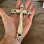 Artisan upcycled knife cross - four hollow handles forming devotional page weight - shown in hand for scale