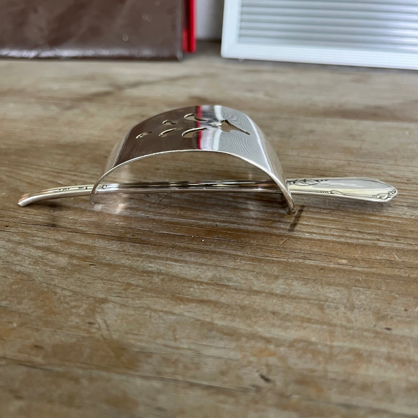 Handcrafted hair barrette from vintage cake server showing dimensional design