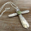 Close-up of unique Regent pattern cross pendant with green-turquoise floral bead - upcycled vintage silverplate statement piece