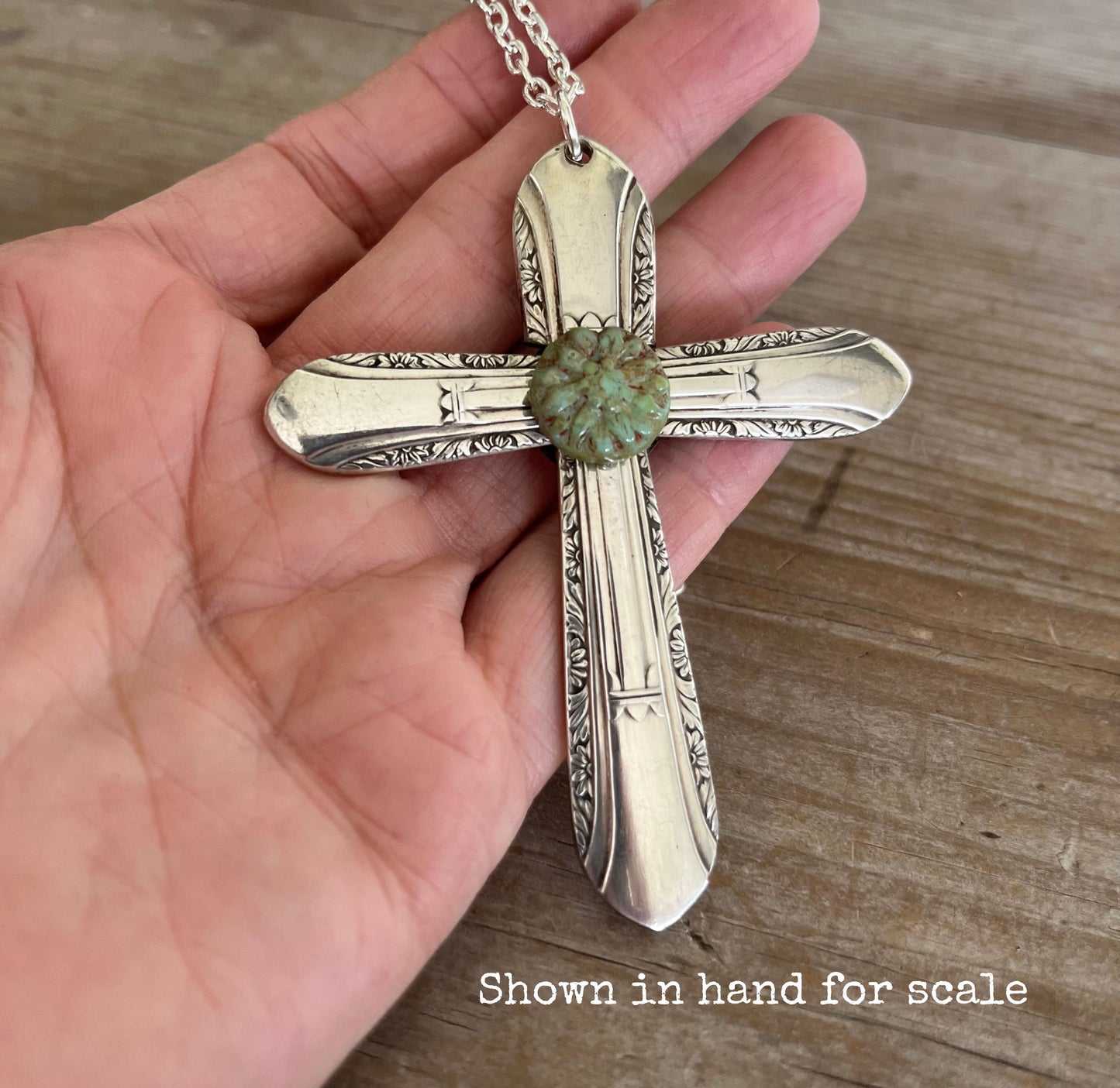 Vintage 1939 William Rogers Regent spoon handles transformed into artisan cross pendant shown in hand for scale