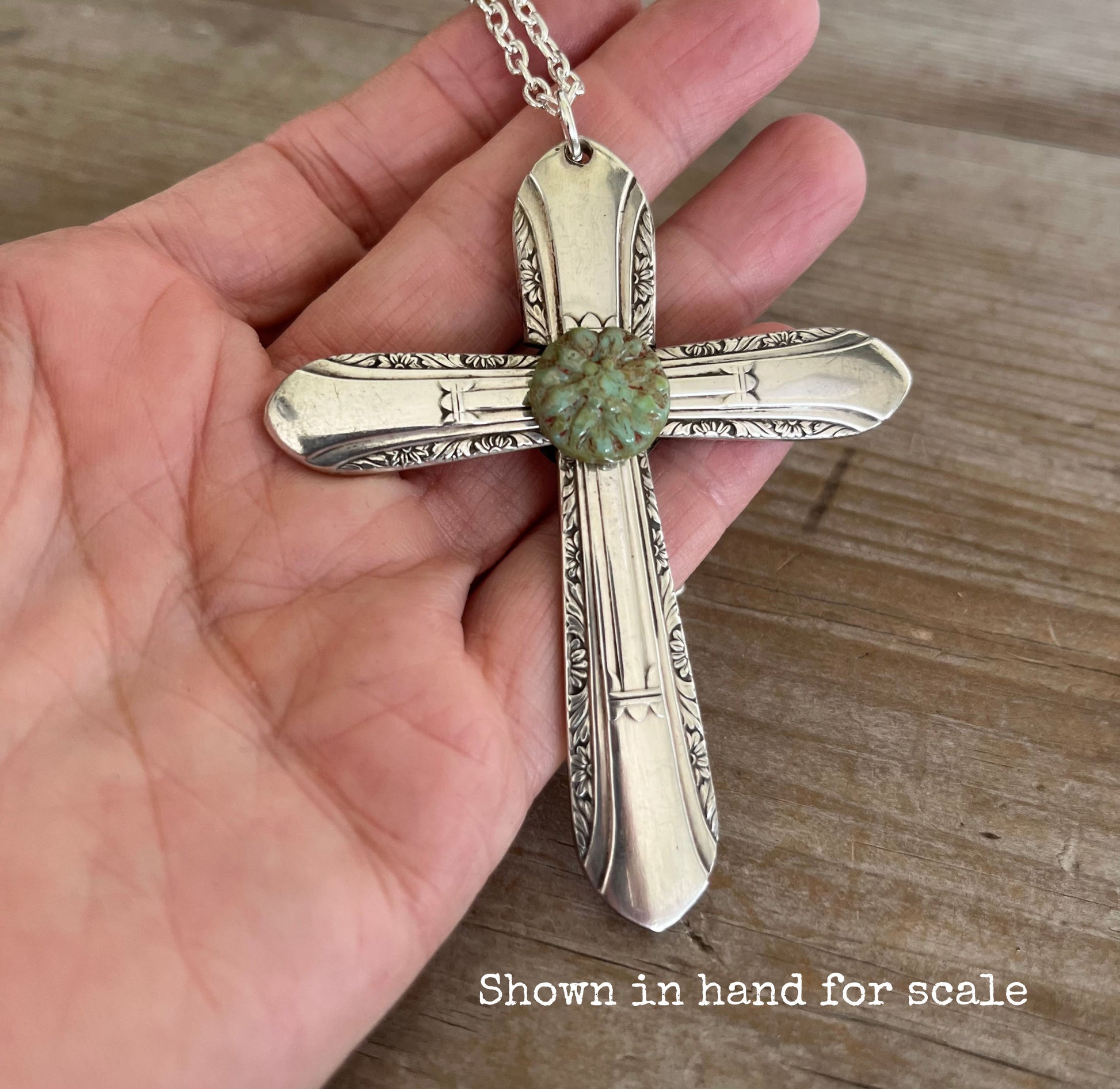 Vintage 1939 William Rogers Regent spoon handles transformed into artisan cross pendant shown in hand for scale