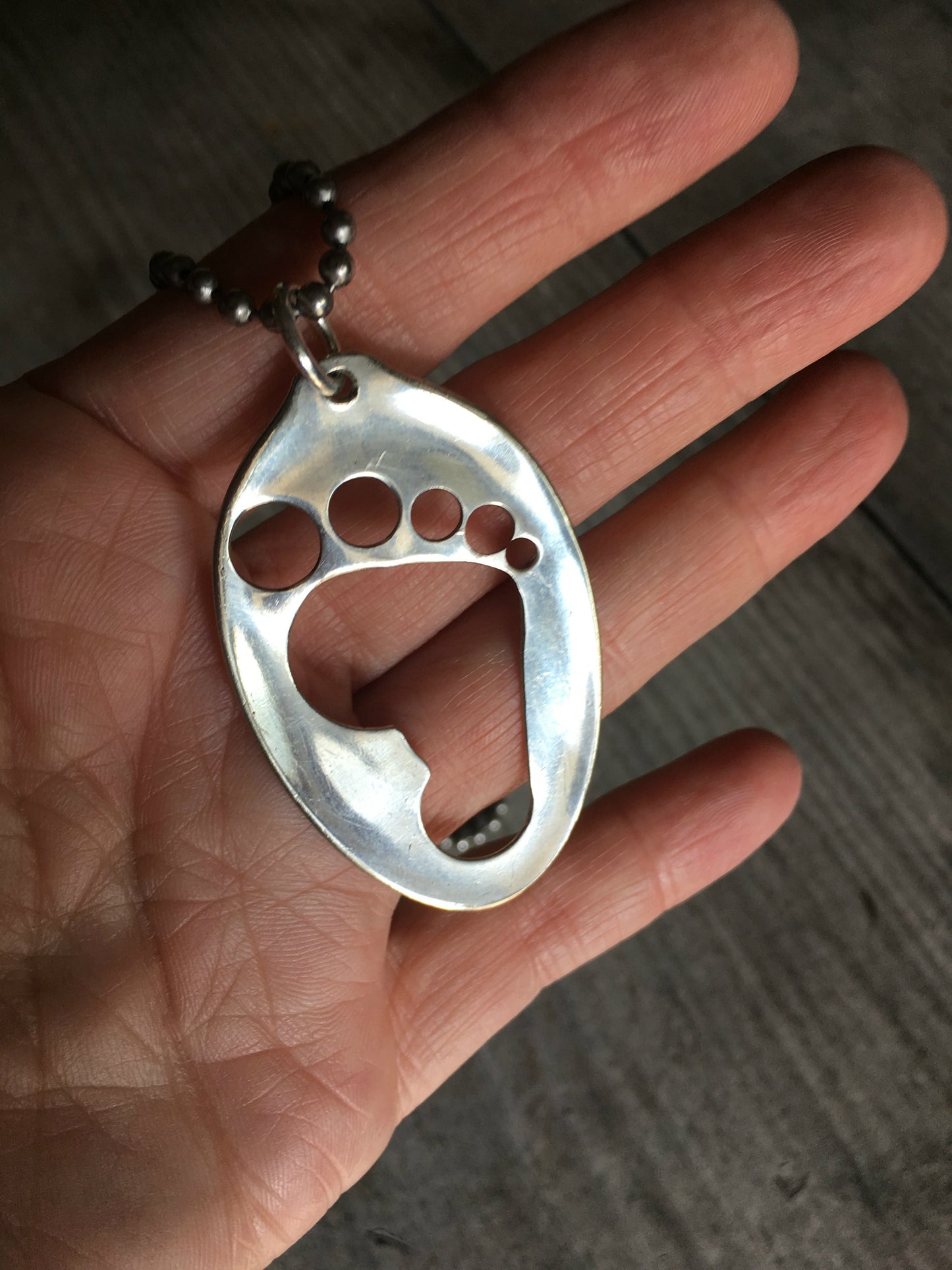 Upcycled Spoon Necklace Hand Punched in Barefoot design Shown in Hand For Scale