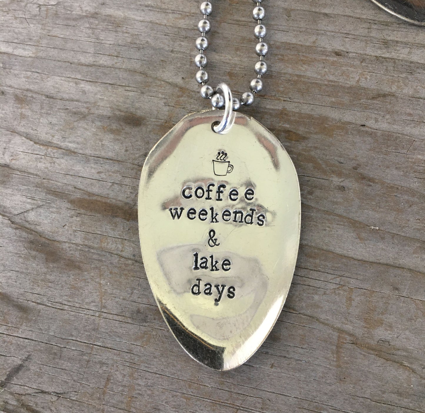 Close-up of COFFEE WEEKENDS & LAKE DAYS hand-stamped spoon pendant showing reclaimed vintage silverware, lake life design