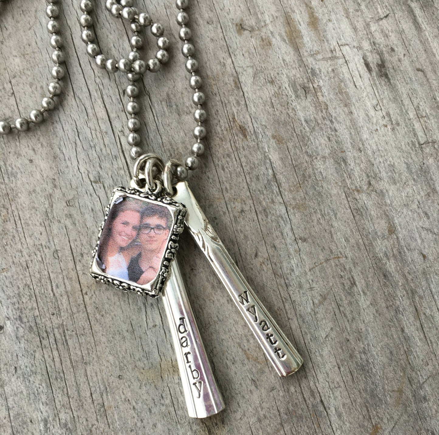 Personalized Cherish Necklace showing two hand-stamped upcycled silverware vertical bars with metal photo frame on stainless steel ball chain"