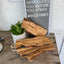 Stack of Italian olivewood charcuterie boards with rustic bark edges and rope handles - handcrafted from 150-year-old wood