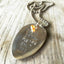 Stamped Spoon Necklace focusing on glass bead