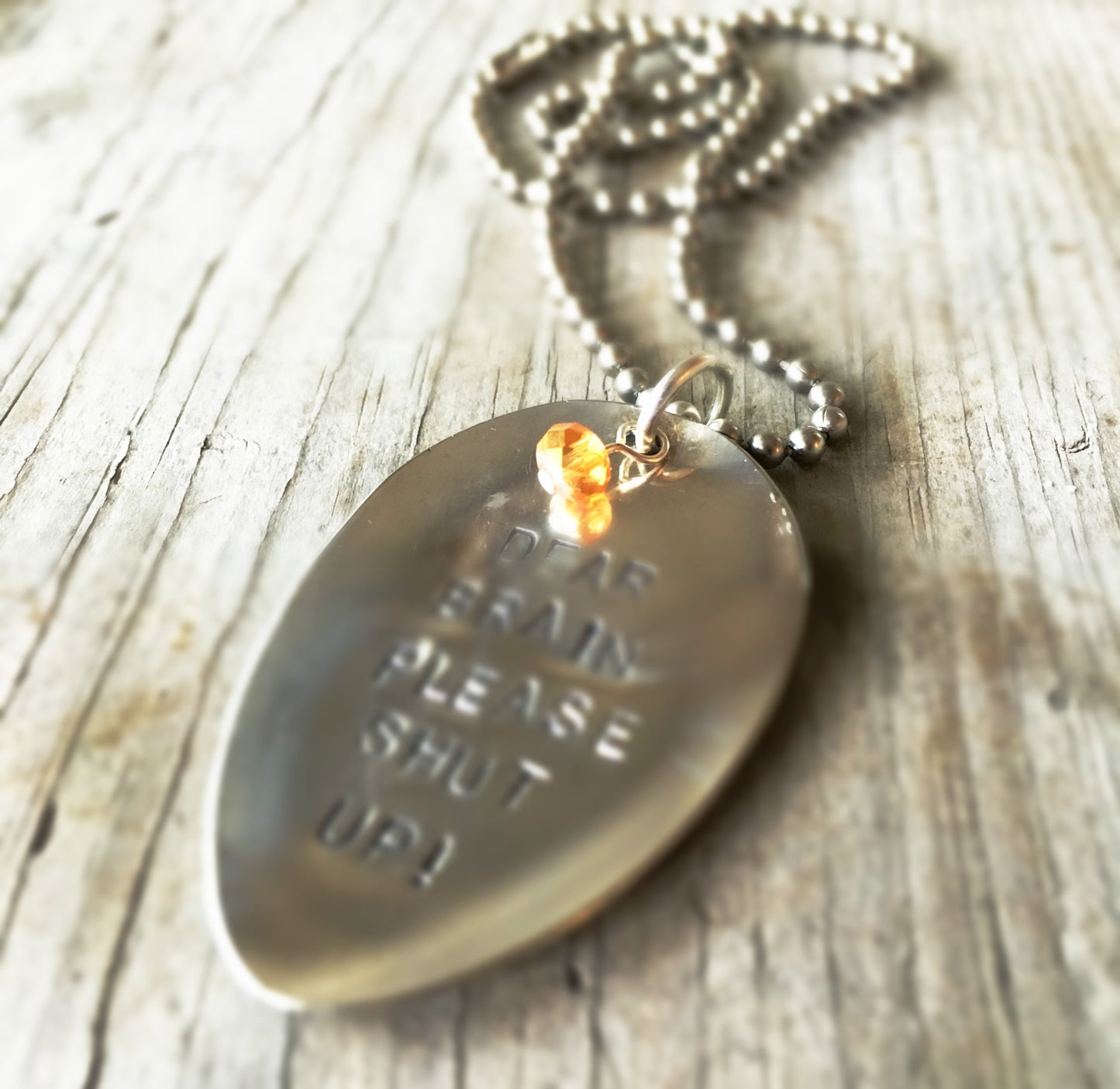 Stamped Spoon Necklace focusing on glass bead