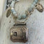 Close-up detail of vintage 1920s belt buckle pendant with turquoise beads - handcrafted upcycled artisan necklace