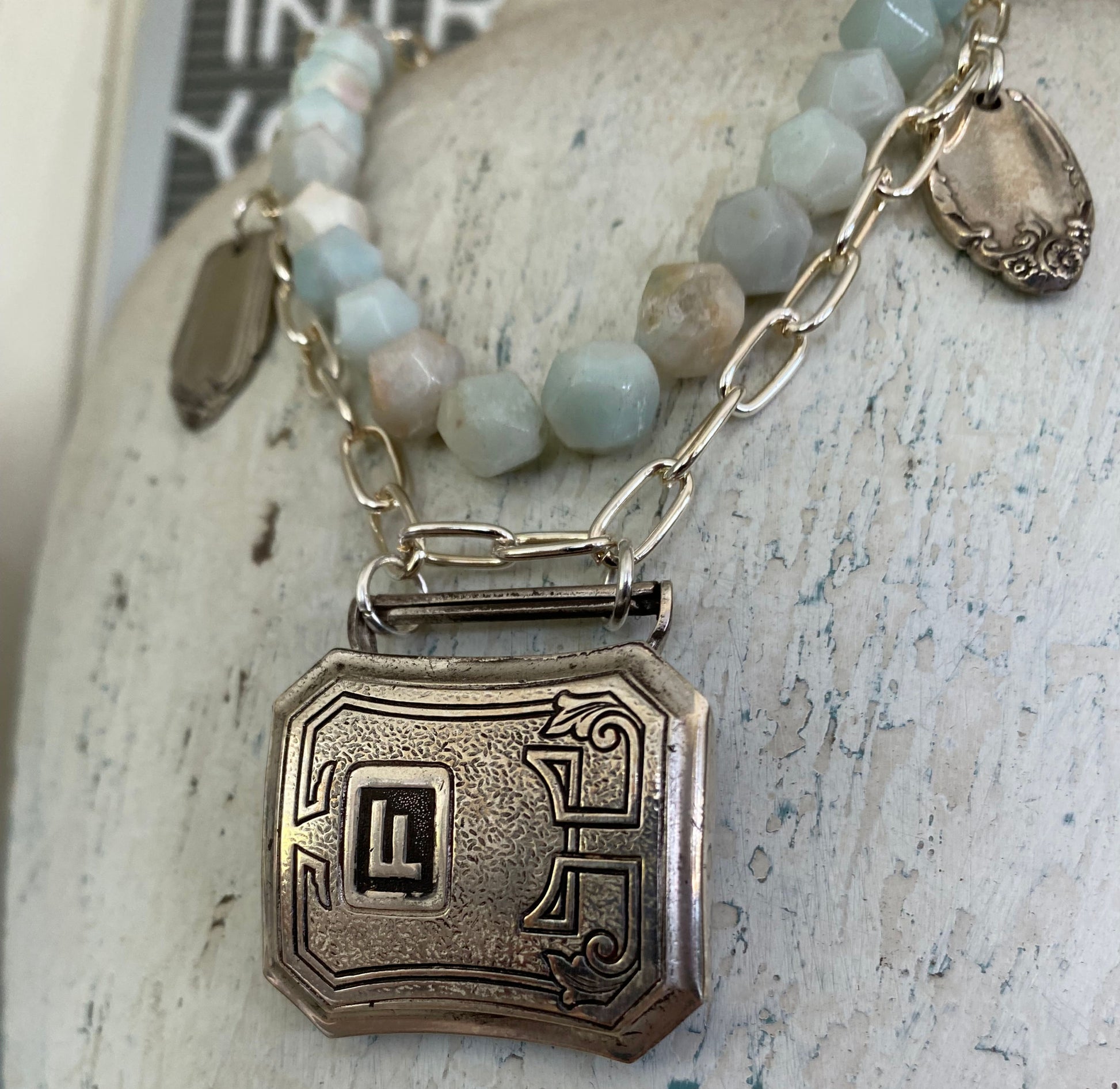 Close-up detail of vintage 1920s belt buckle pendant with turquoise beads - handcrafted upcycled artisan necklace