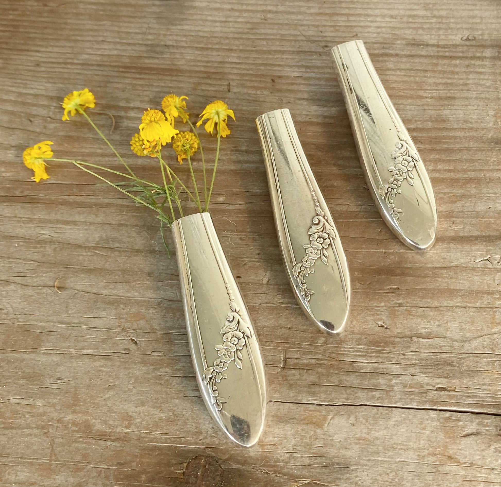 Trio of upcycled silverplate knife vases with magnet displaying vintage Queen Bess floral pattern and holding flowers