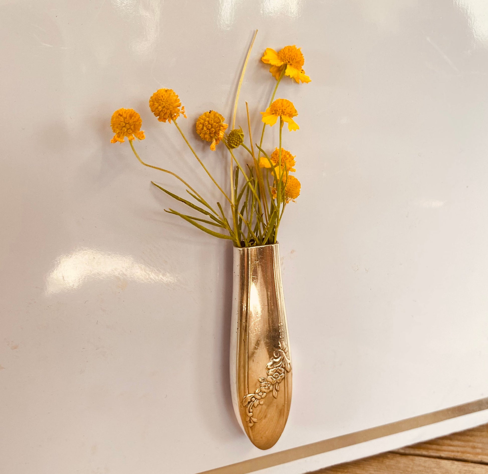 Upcycled vintage 1946 Tudor Plate Queen Bess silverplate knife vase with magnet holding flowers on metal surface