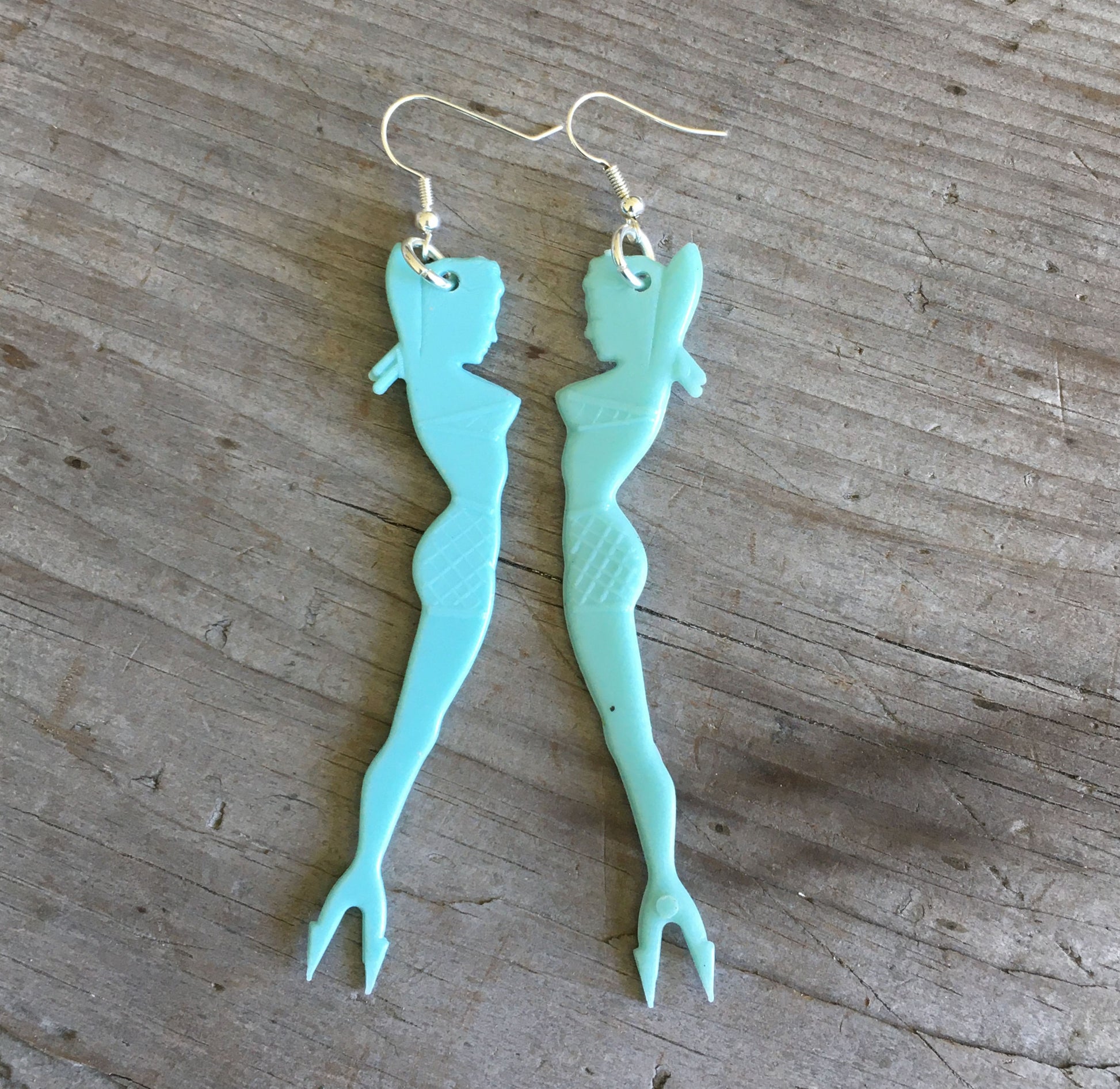 Vintage pinup mermaid swizzle stick earrings showing double-sided design with forked tail, 3.5 inches long