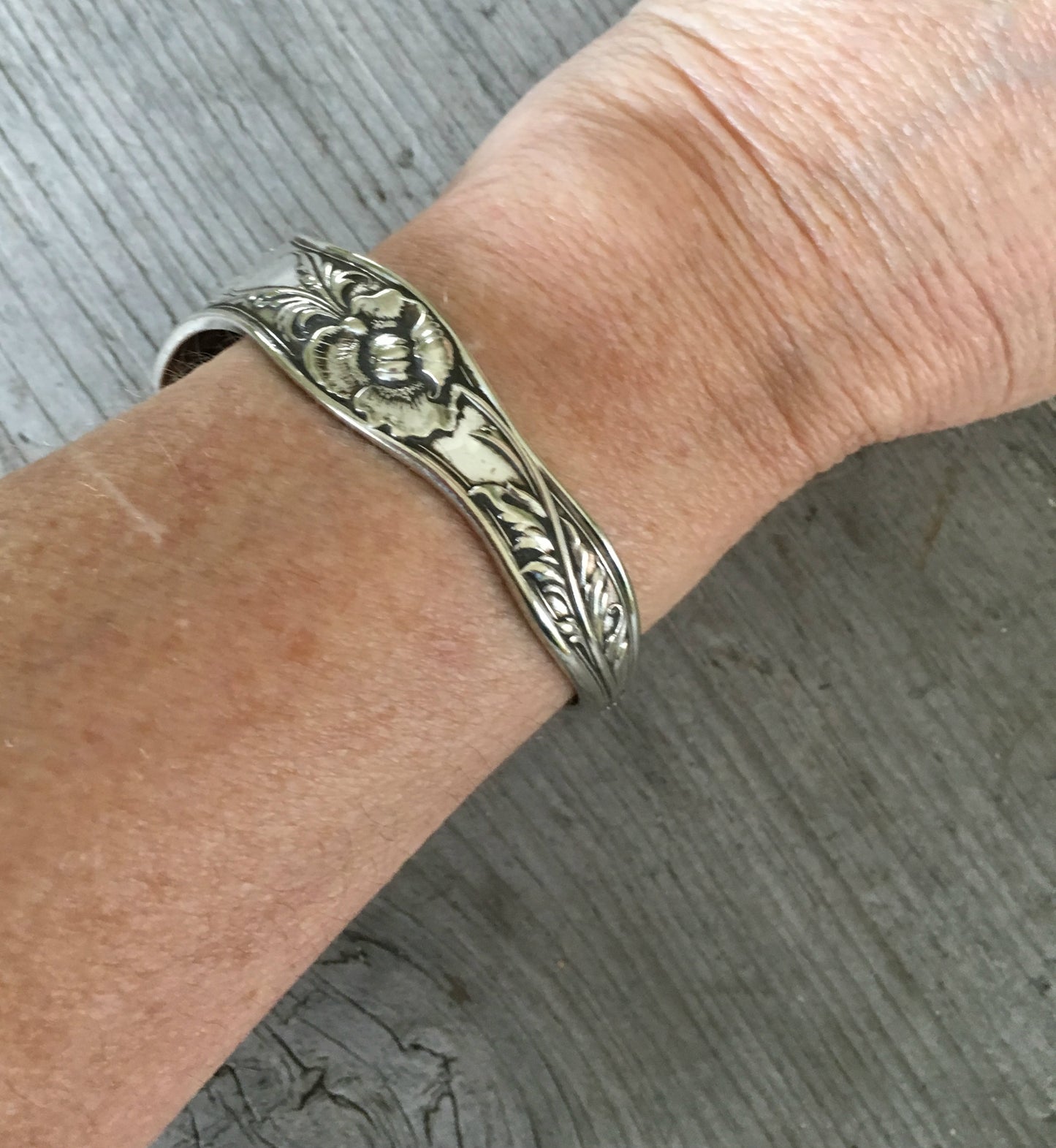 Reed and Barton Poppy pattern cuff bracelet worn on wrist - handcrafted from upcycled vintage silverware - Laughing Frog Studio