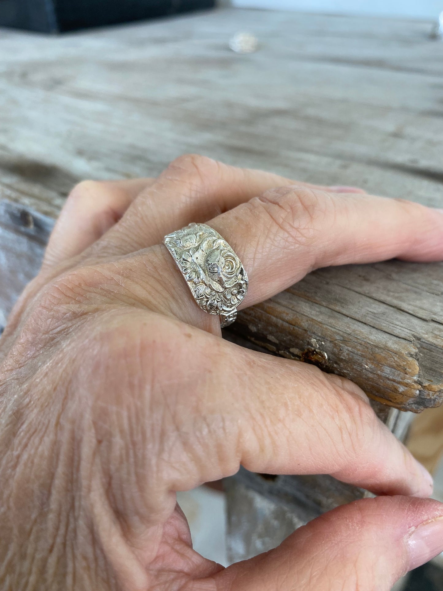 Antique Kirk & Son Repoussé sterling silver spoon ring on hand displaying ornate floral pattern