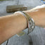 Carnation pattern spoon cuff bracelet shown on a wrist - handcrafted from upcycled vintage silverware - Laughing Frog Studio