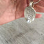 Spoon keychain hand stamped with HOME IS WHERE your mom is shown in hand for size and scale