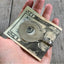 Spoon money clip shaped like banjo shown in hand for visual scale