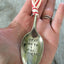Upcycled spoon ornament shown in hand for scale