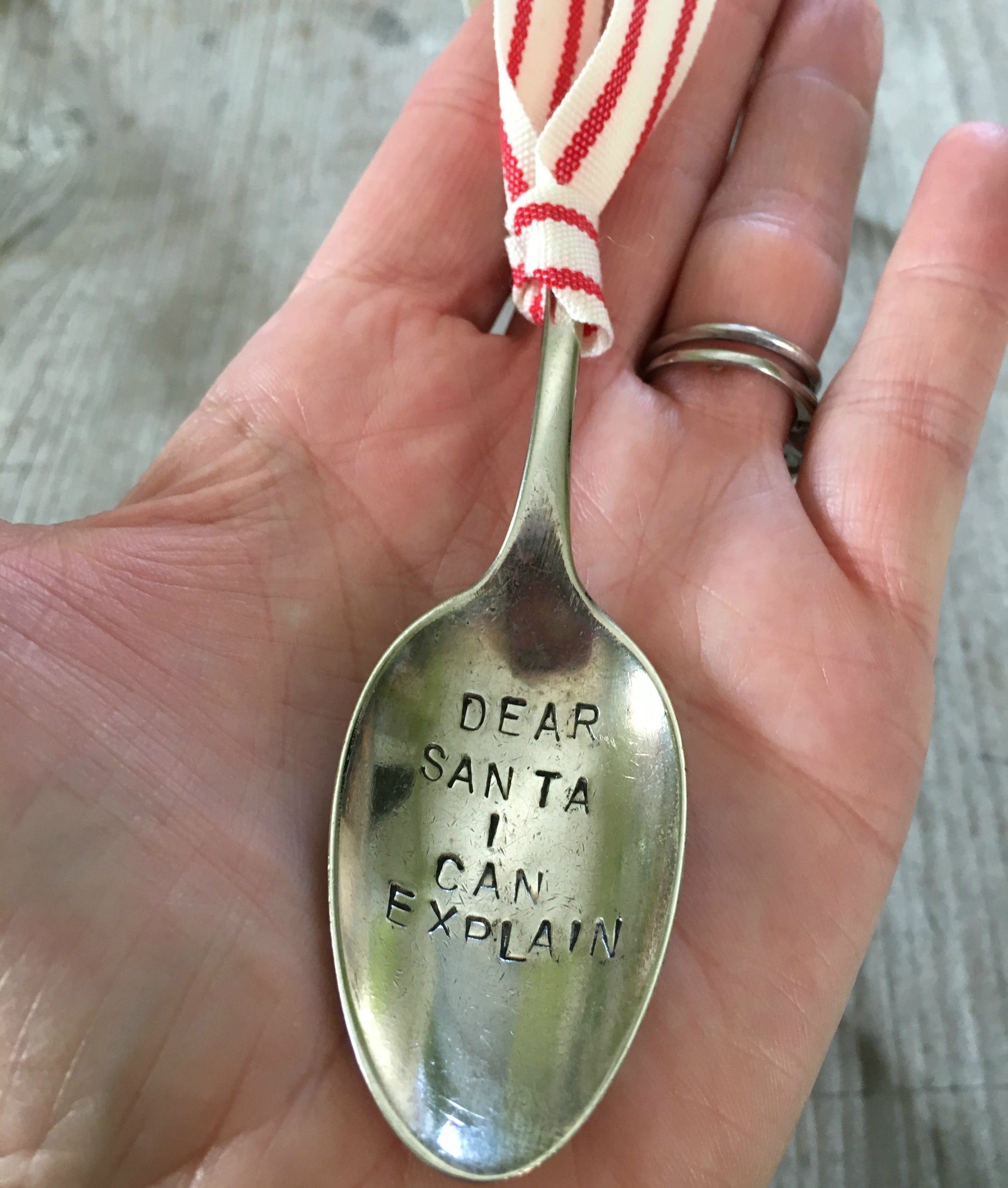 Upcycled spoon ornament shown in hand for scale