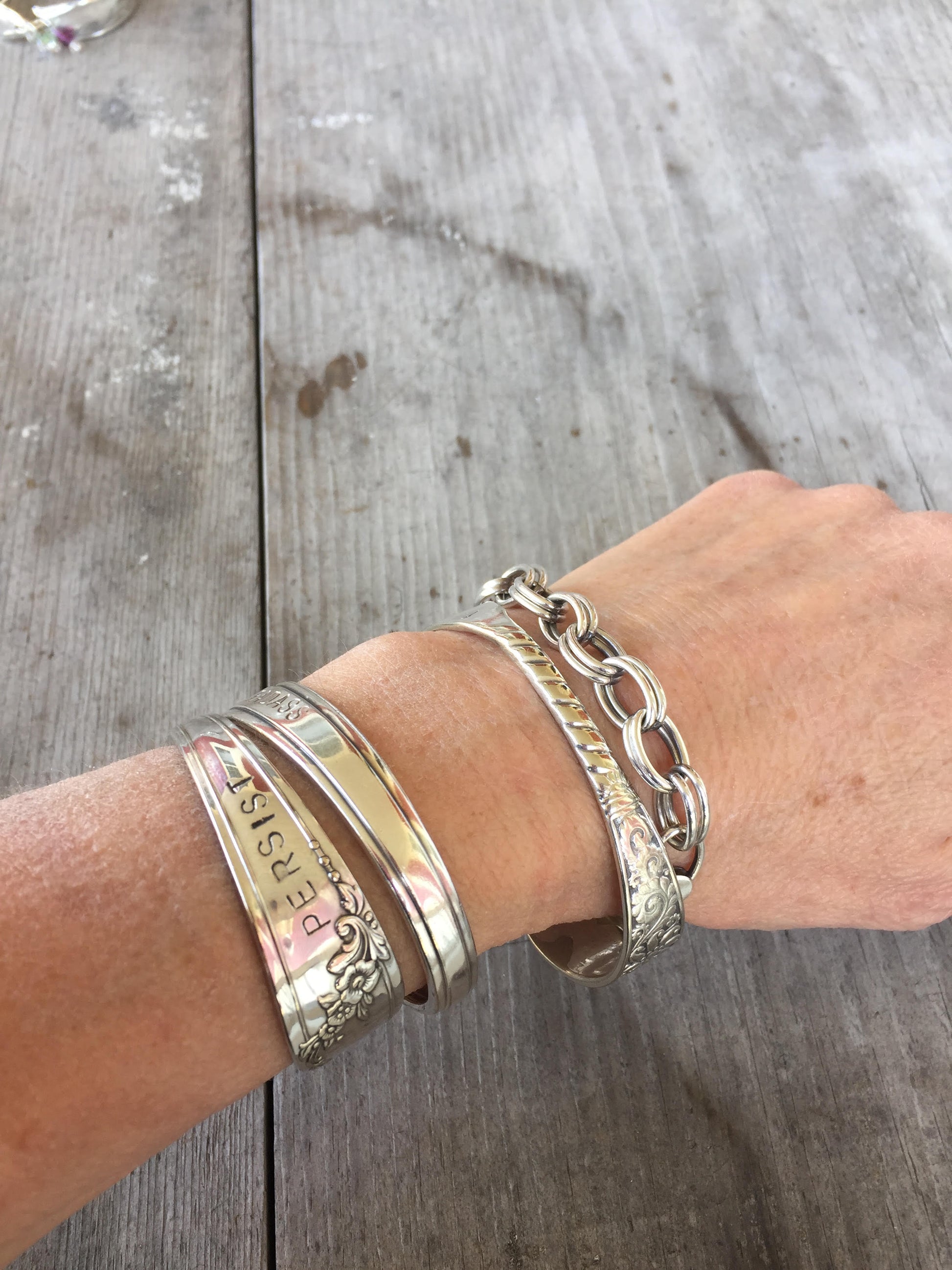 Handstamped spoon cuff bracelet Persist shown on model wrist