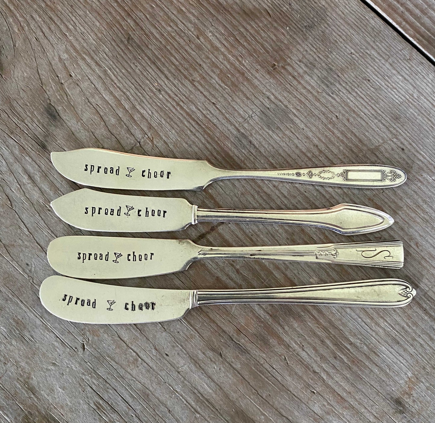 Collection of vintage butter knives hand-stamped with Spread Cheer message for holiday entertaining