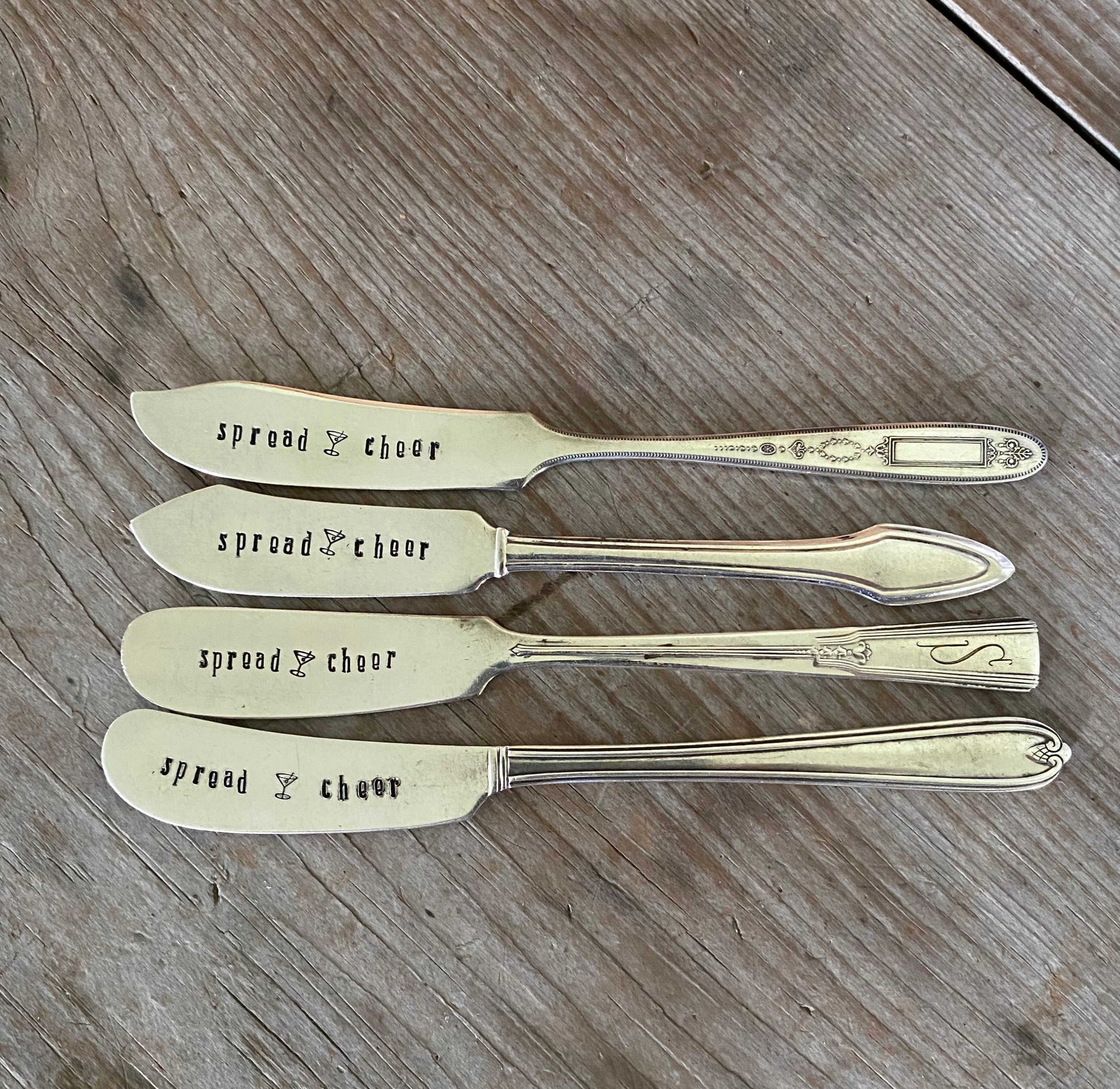 Collection of vintage butter knives hand-stamped with Spread Cheer message for holiday entertaining