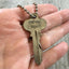 key necklace HAND stamped with gypsy soul shown in hand for scale