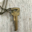 Back side of Vintage Gold Tone Hand Stamped Key LIVE FREE on ball chain
