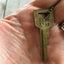Close up of Vintage Gold Tone Hand Stamped Key LIVE FREE on ball chain