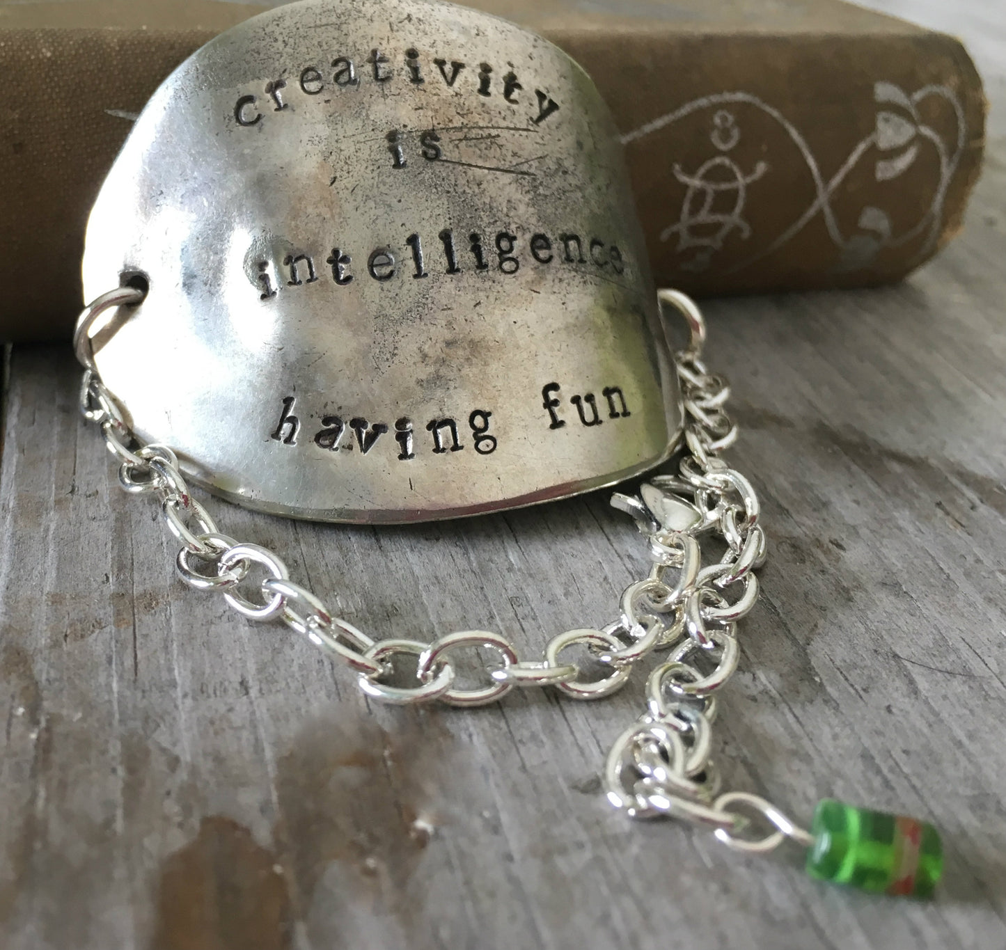 Stamped spoon bracelet with green cylinder millifiori bead