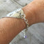 Stamped Spoon Bracelet Love is Love shown on models arm illustrating adjustable sizing chain