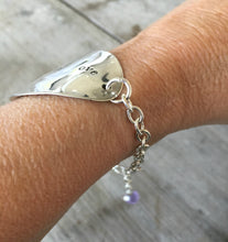 Stamped Spoon Bracelet Love is Love shown on models arm illustrating adjustable sizing chain