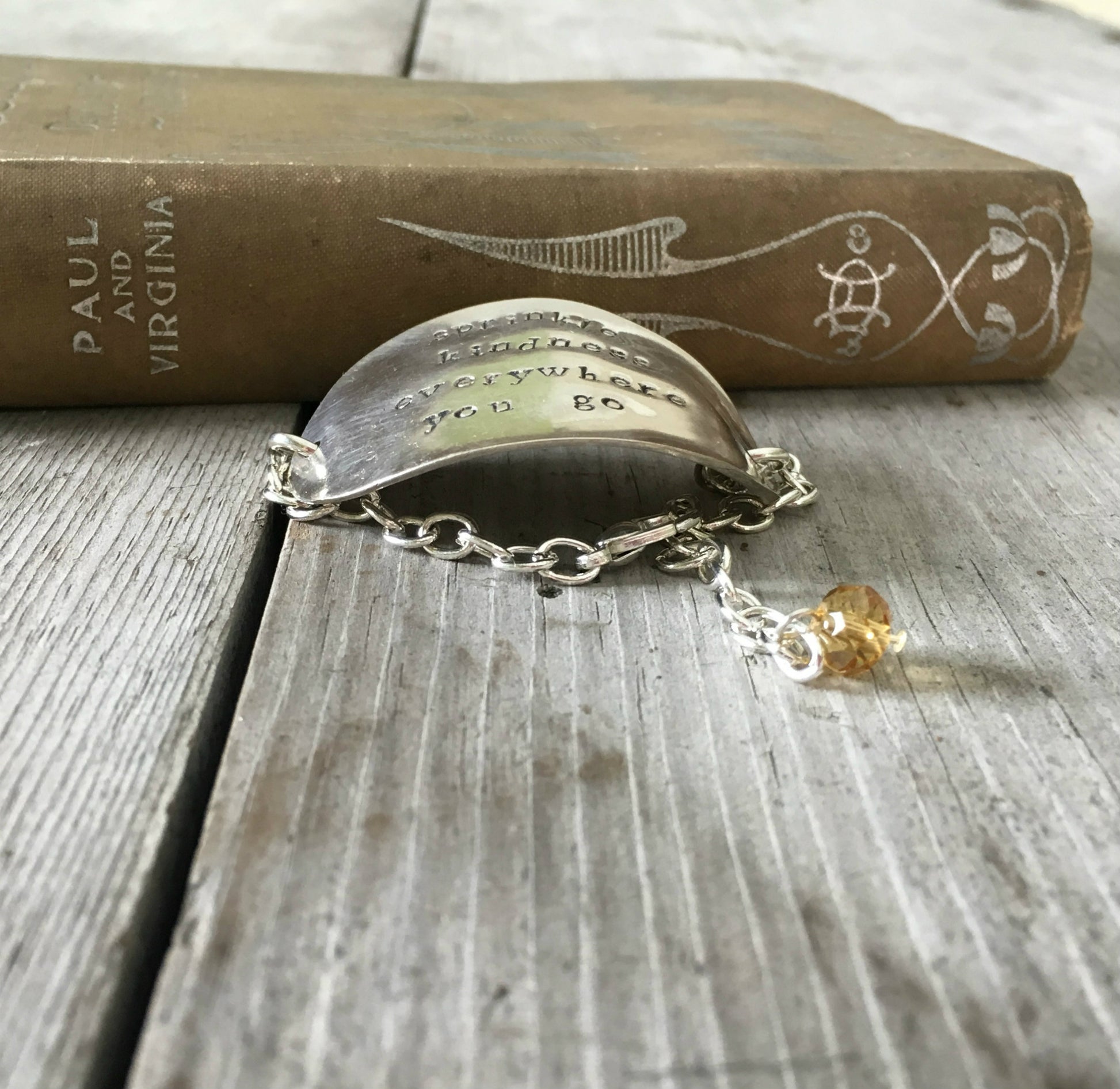 Side view of stamped spoon bracelet about kindness