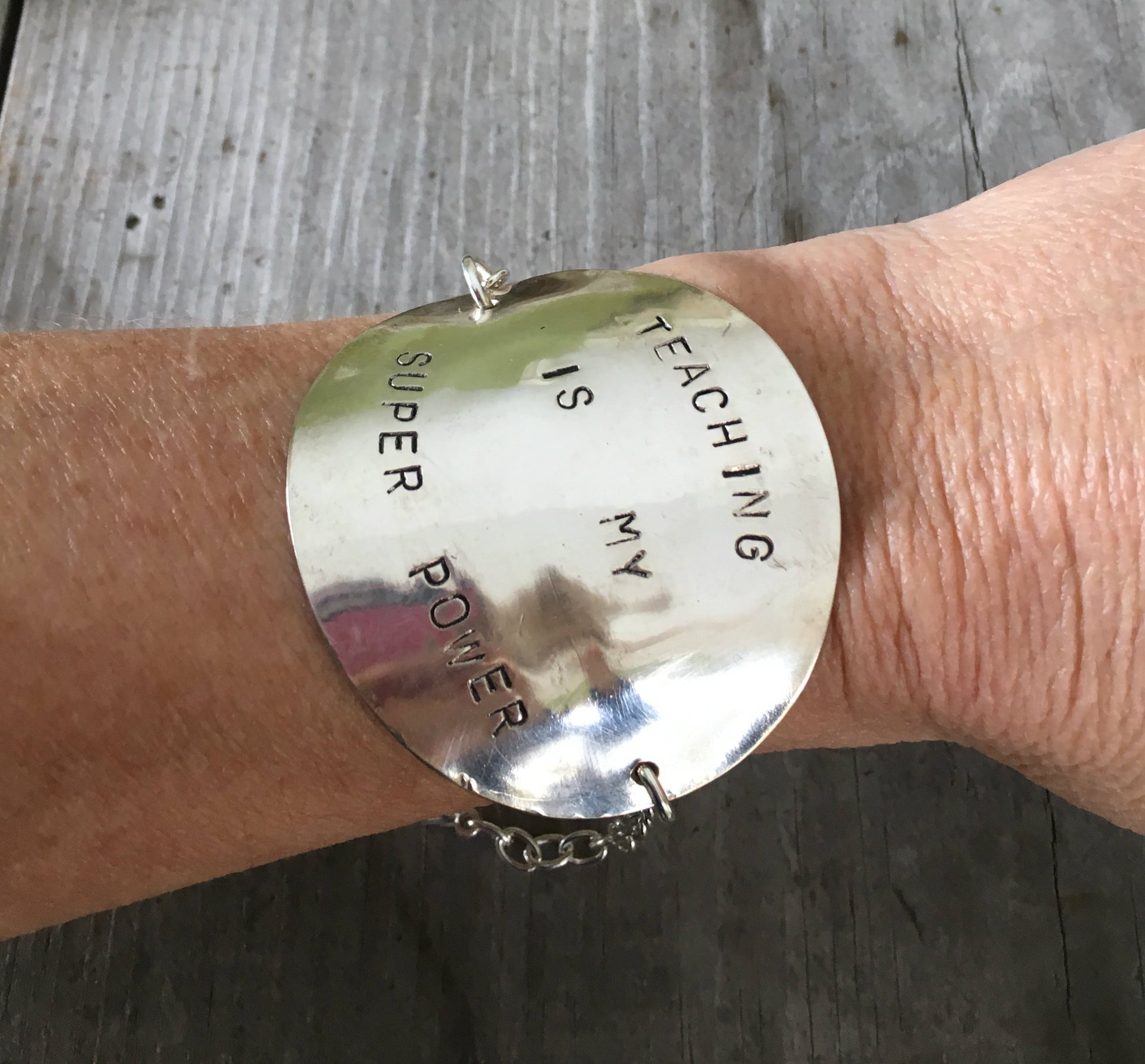 Upcycled silverware teacher appreciation bracelet worn on wrist, showing adjustable chain 