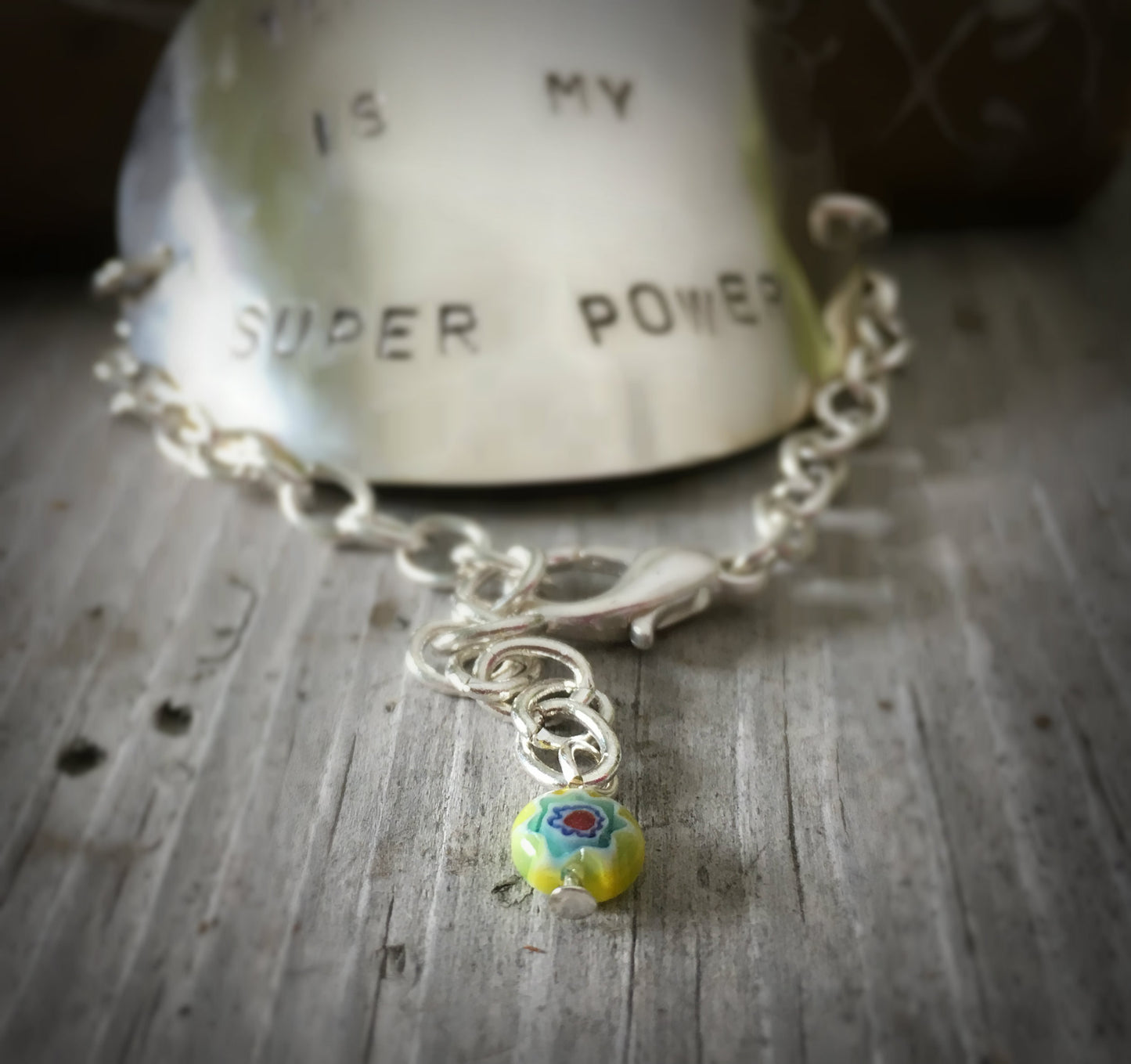 Upcycled silverware teacher appreciation bracelet showing adjustable chain and yellow glass bead accent