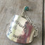 Close-up of hand-stamped wanderlust lettering and earthy turquoise glass bead on flattened vintage spoon bowl bracelet