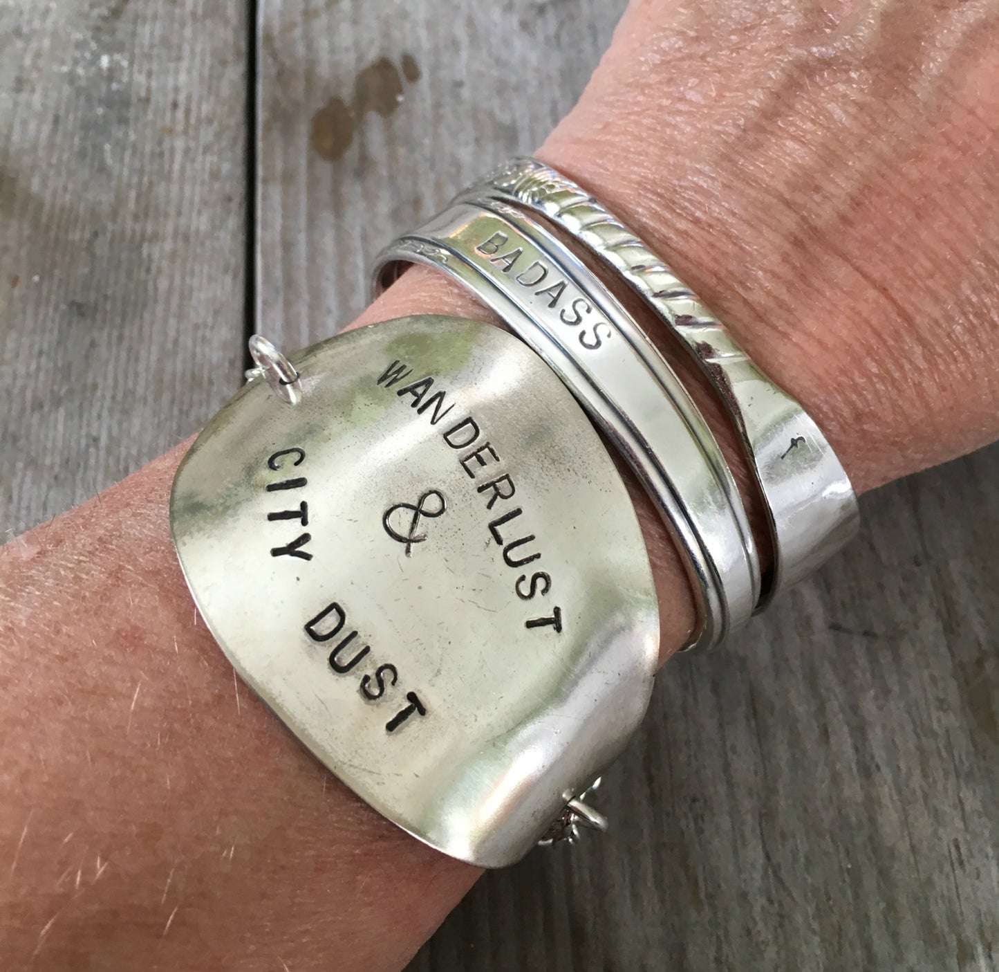 upcycled silverware bracelet with wanderlust message worn on wrist for size and scale